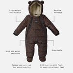 Anders choco leopard print snow suit, featuring a plush cream fleece lining and bear ears on the hood. The image includes text callouts with dotted lines pointing to features like 'Lightweight and durable', 'Machine washable', 'Wind and water resistant', 'Breathable', 'Padded and quilted for extra comfort', and '0-12 months with feet, 12 months+ without feet'.