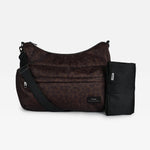 The Clara changing bag in chocolate leopard with a black strap and a black changing mat, displayed against a solid light gray background.