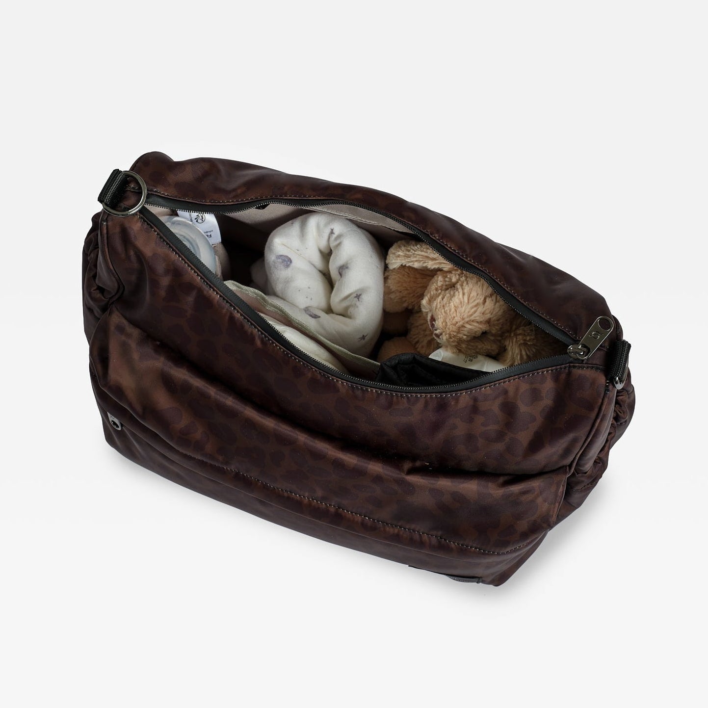The Finnson chocolate leopard Clara changing bag shown open, revealing stuffed items inside, photographed on a clean white background.