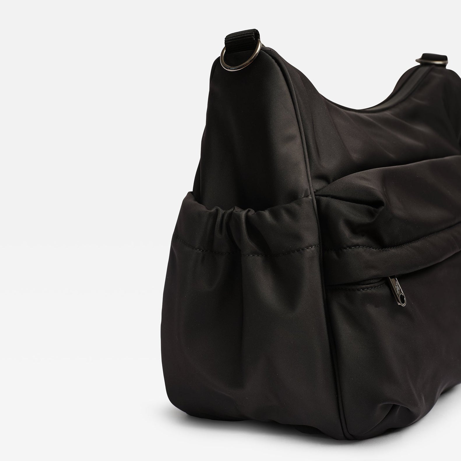 Clara changing bag in black nylon bag with a drawstring front pocket and a zippered side pocket, photographed on a clean white background.