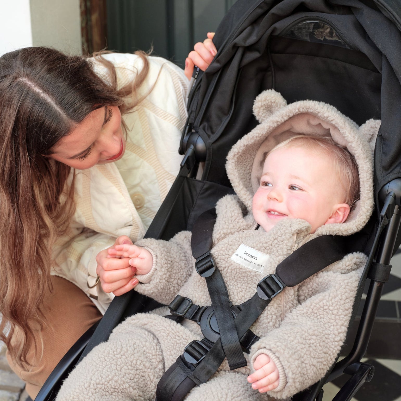 Woman with a baby in a stroller wearing Alf borg beige eco pram suit