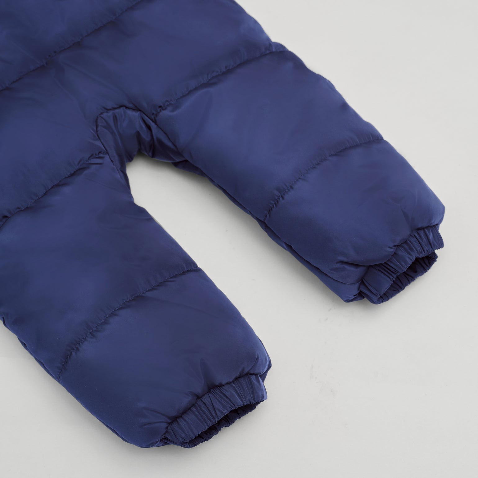Close up of photo of Anders navy snowsuit  on a light gray background