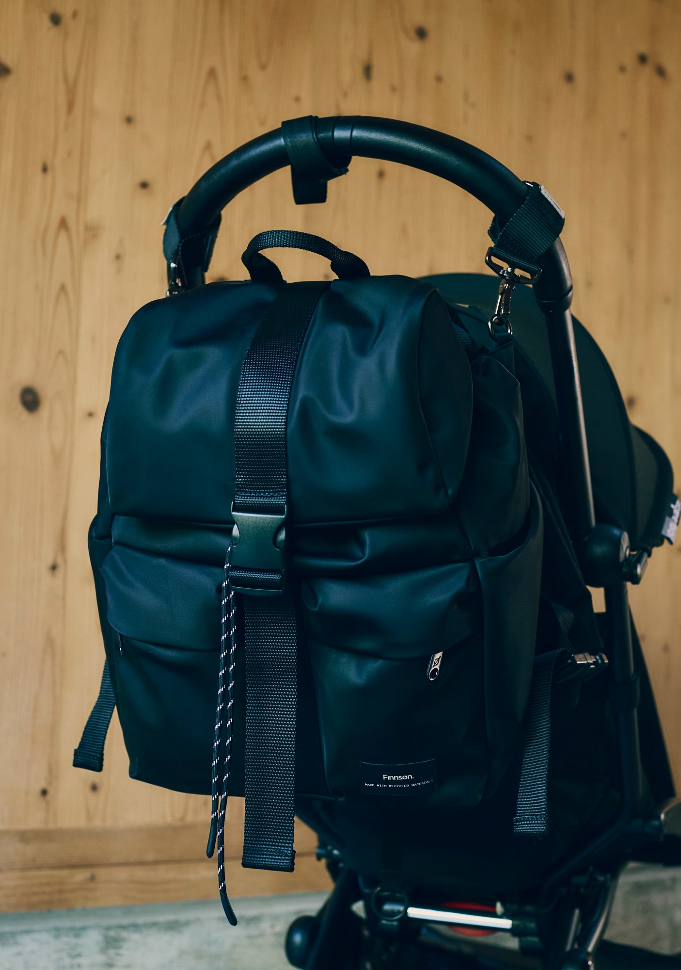 Elise Black changing backpack attached to a stroller against a wooden background