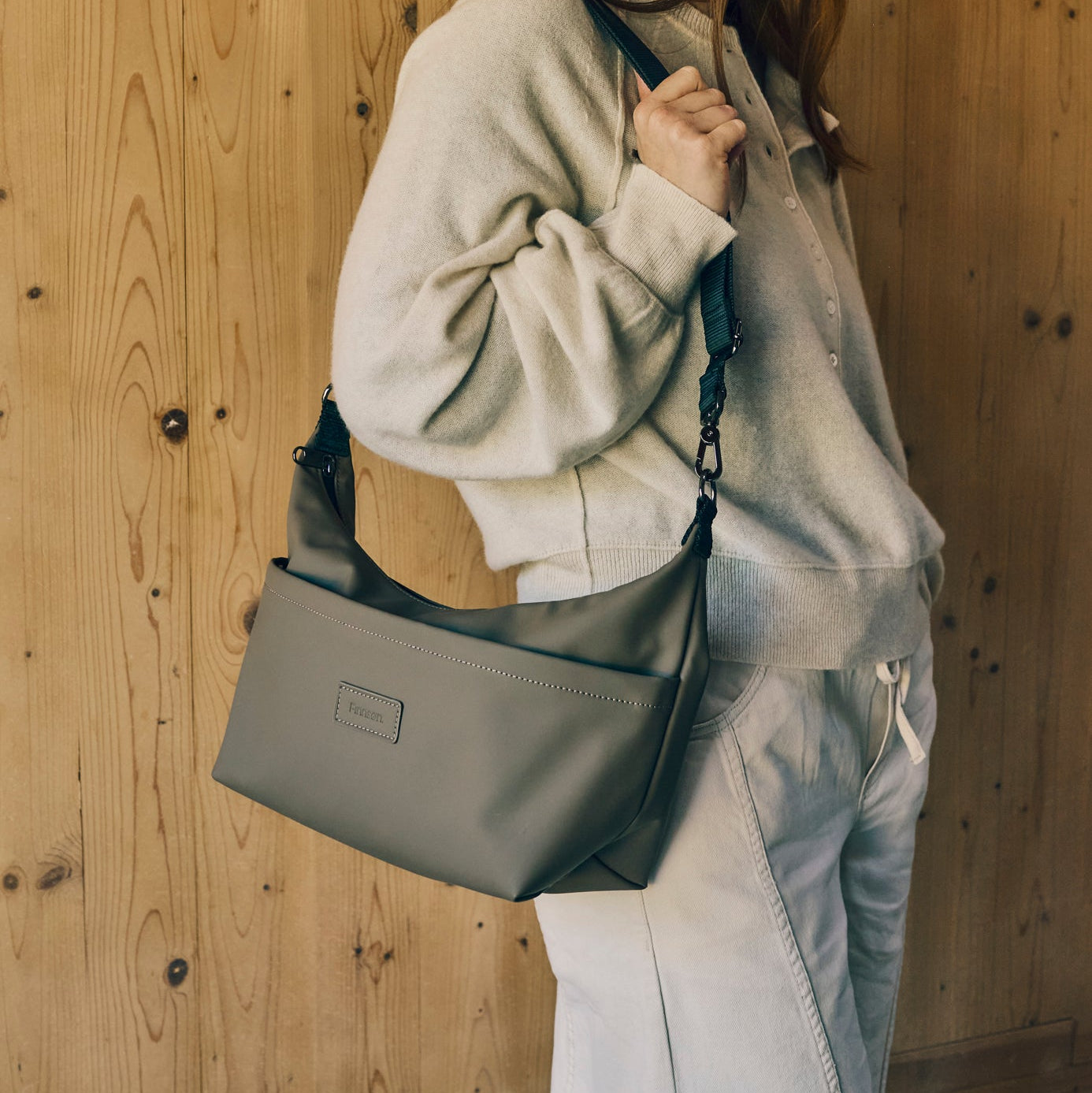 Women holding fia mocha stroller organiser against a wooden background