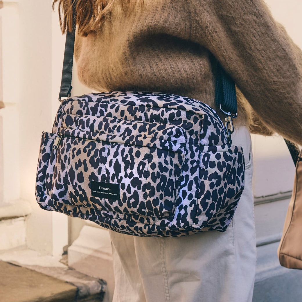 Person wearing the freya leopard print bag with a blurred background
