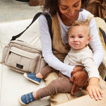 FINNSON FREYA OVERSIZED STROLLER ORGANISER TAUPE MODEL WEARING ON SHOULDER HOLDING BABY 