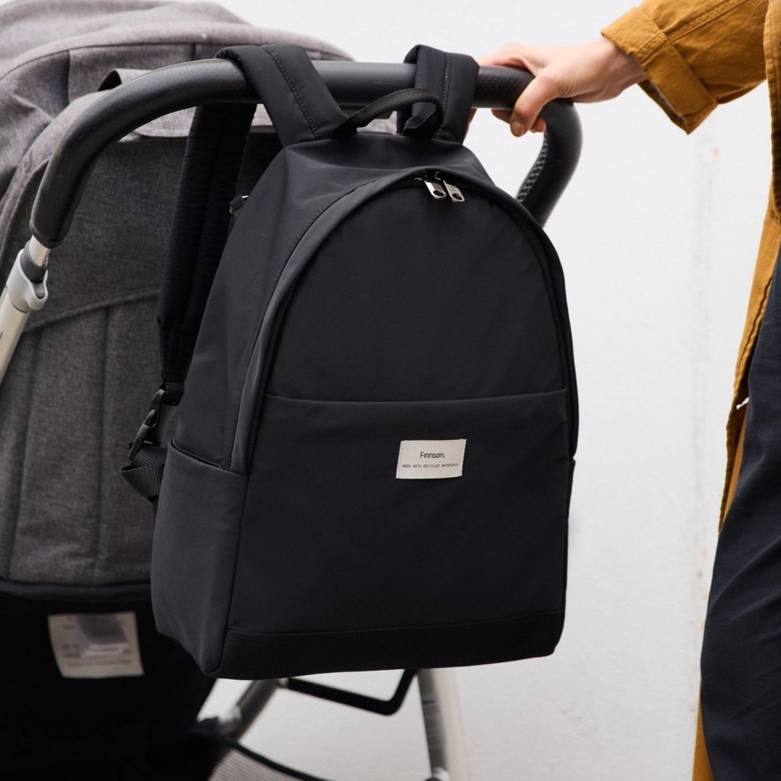 FINNSON INGE BLACK BACKPACK ON BACK OF PRAM