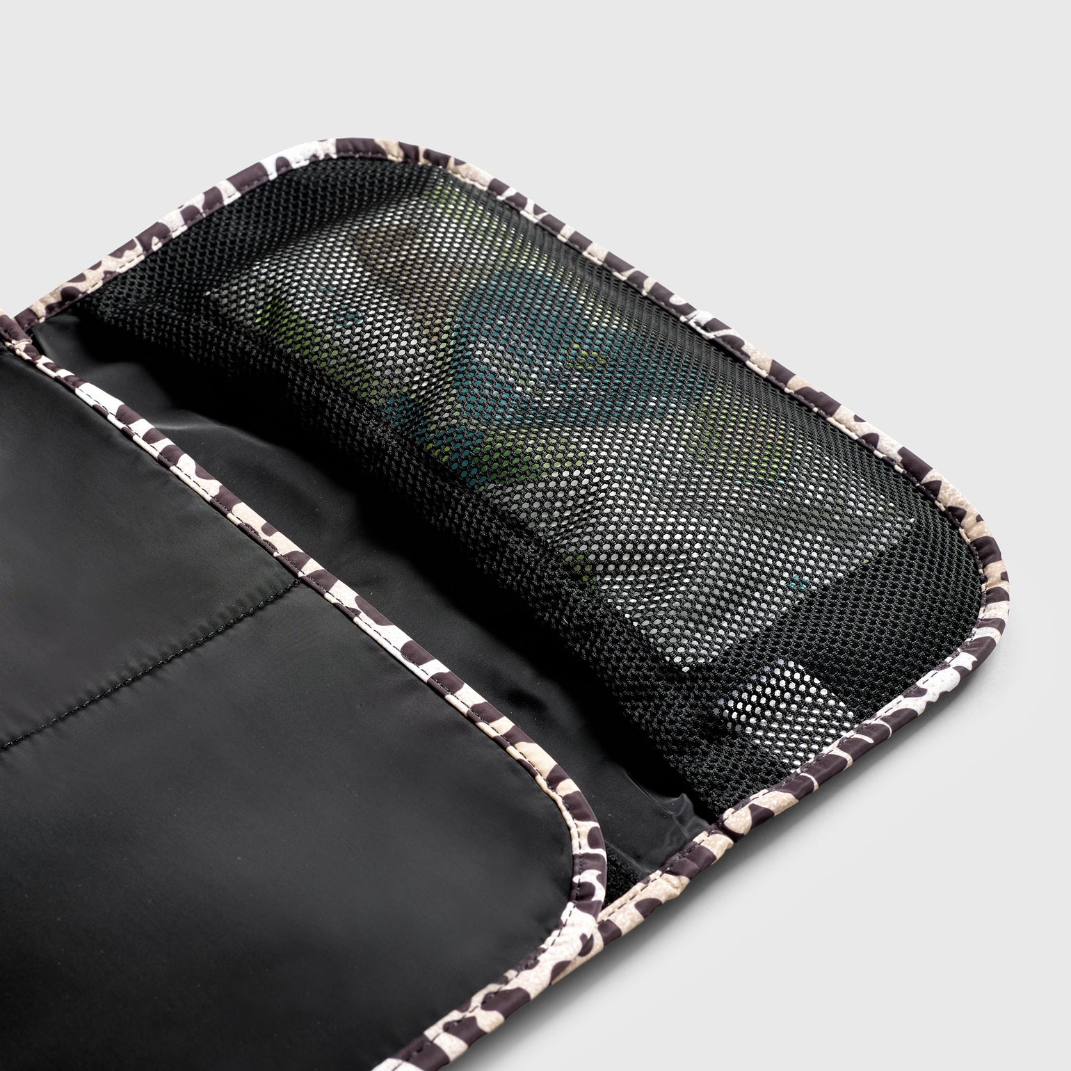 Close up look of oslo leopard print travel changing mat, shown open showing the Internal mesh pocket for nappies, wipes and/or creams.