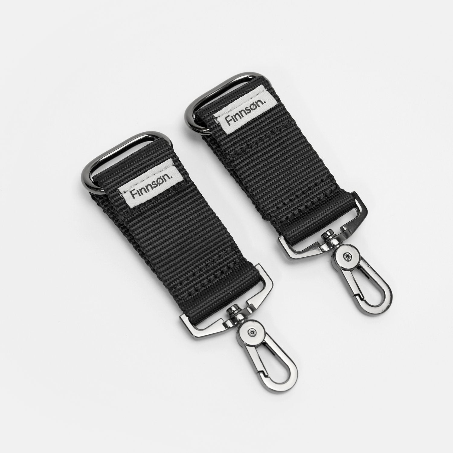 A pair of osten universal stroller clips with the brand name 'Finnsøn' on them, designed to attach bags to stroller or pram handles.