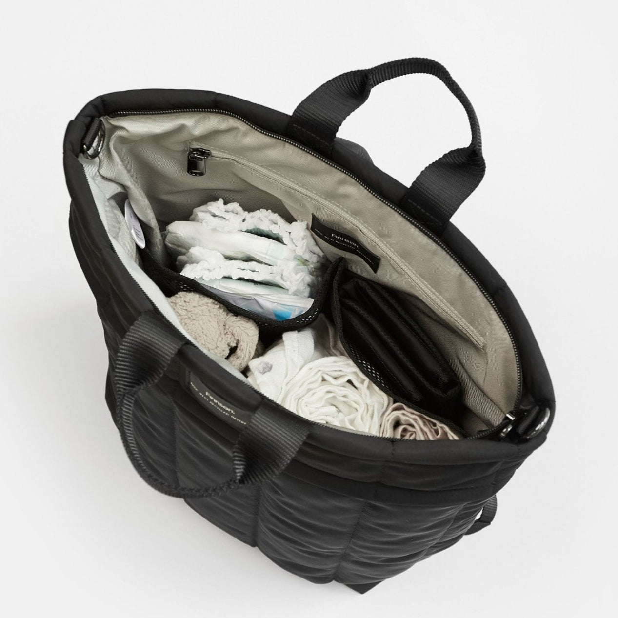 Rae black Eco Changing Backpack with baby essentials neatly organised inside, showcasing its spacious and practical design.