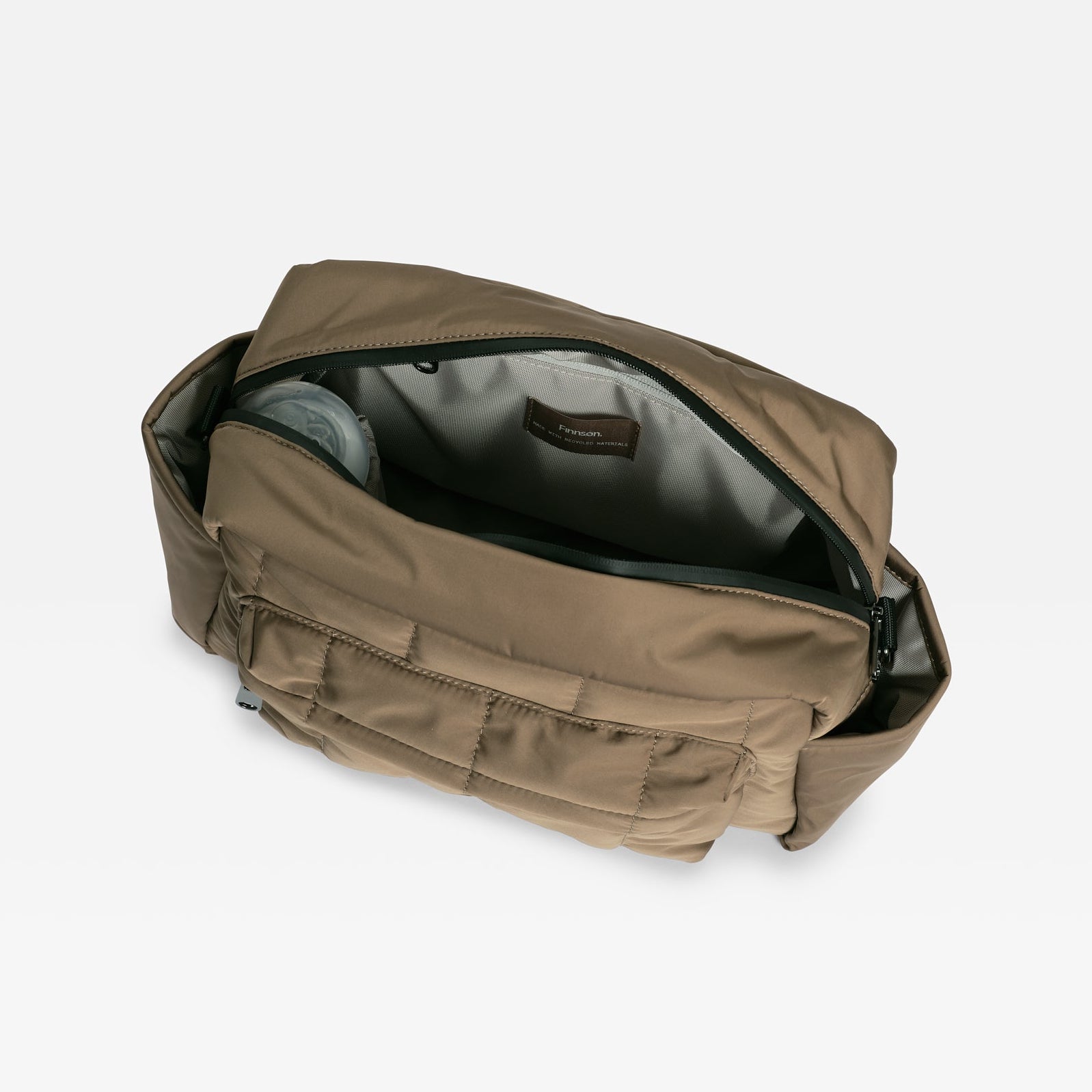 An open mocha bag with multiple zippered pockets and a gray interior lining, shown on a light gray background.