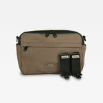 A mocha nylon messenger bag with black accents, including a black zipper, black side loops, and two black quick-release strap attachments, shown against a plain white background.