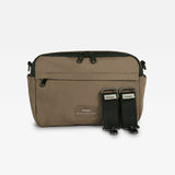 A mocha nylon messenger bag with black accents, including a black zipper, black side loops, and two black quick-release strap attachments, shown against a plain white background.