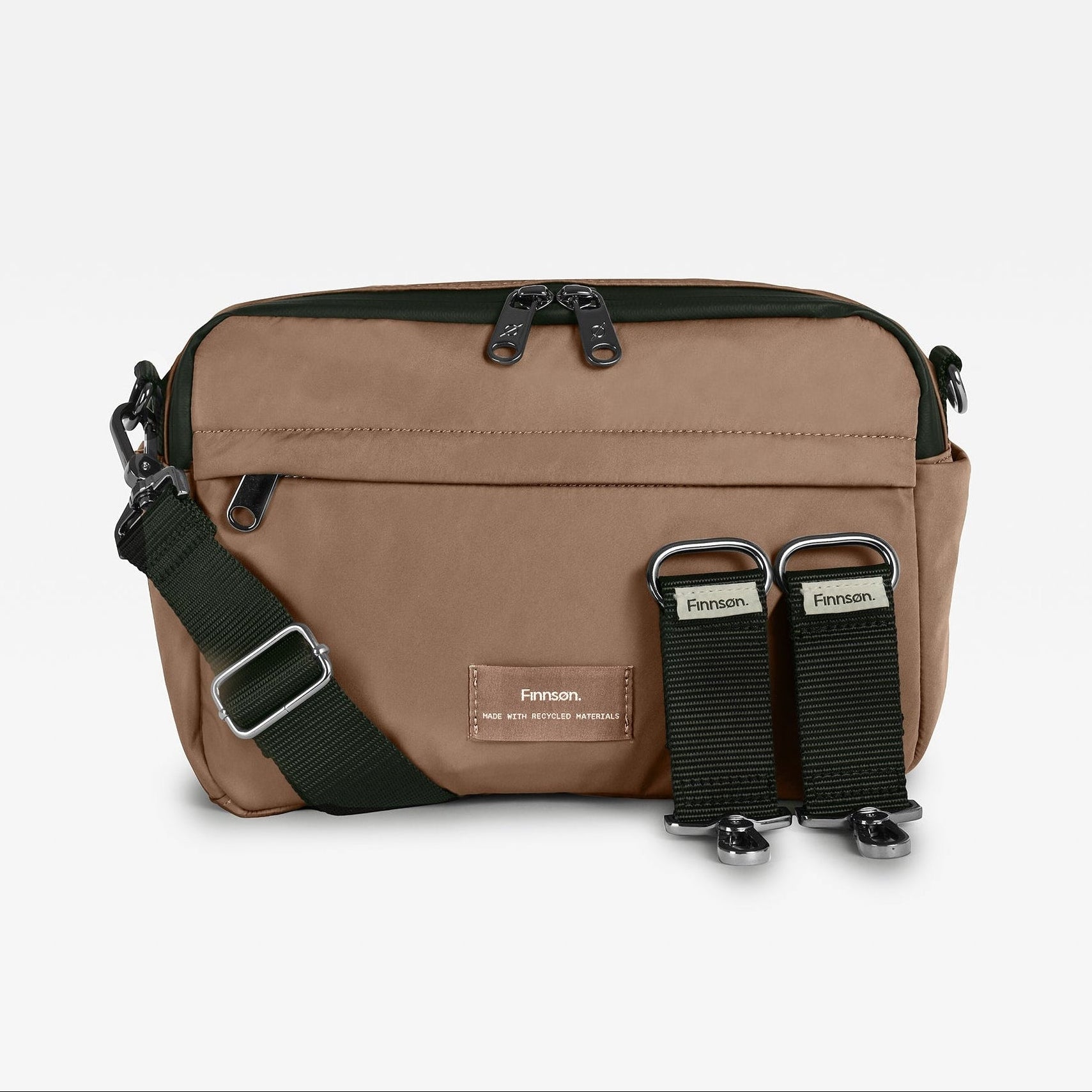 Frida Mocha bag with black accents, featuring a front zip pocket, an adjustable dark green webbing strap, and two black quick-release buckle straps on the front, displayed on a light gray background.