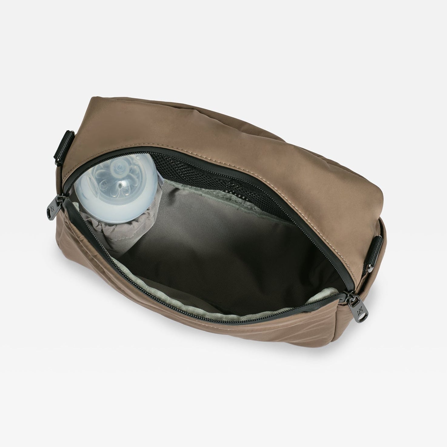 A mocha diaper bag shown open, revealing a dark gray interior and a clear plastic liner inside, set against a plain light gray background.