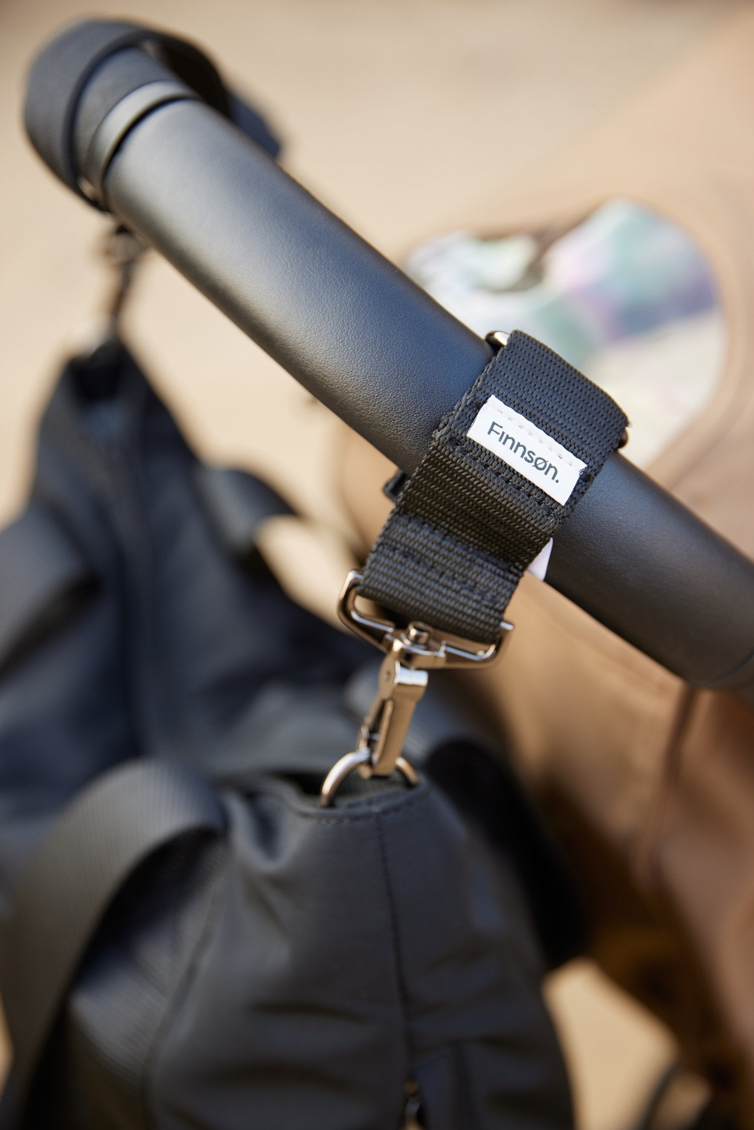 Showing the osten universal stroller clips attached to the stroller 