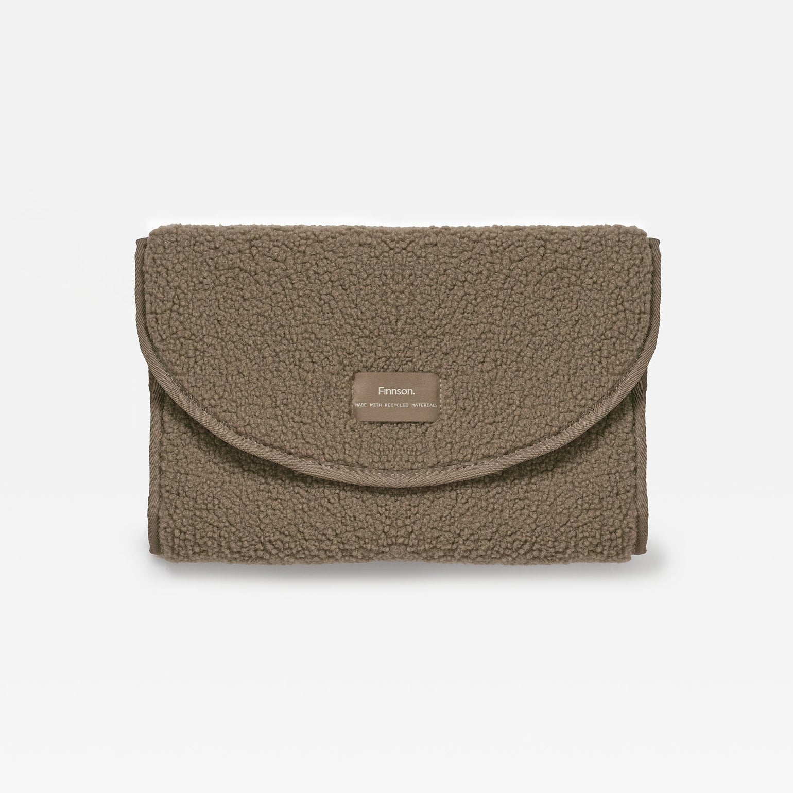 A mocha teddy changing mat with a small rectangular woven label on the front flap, set against a plain white background.