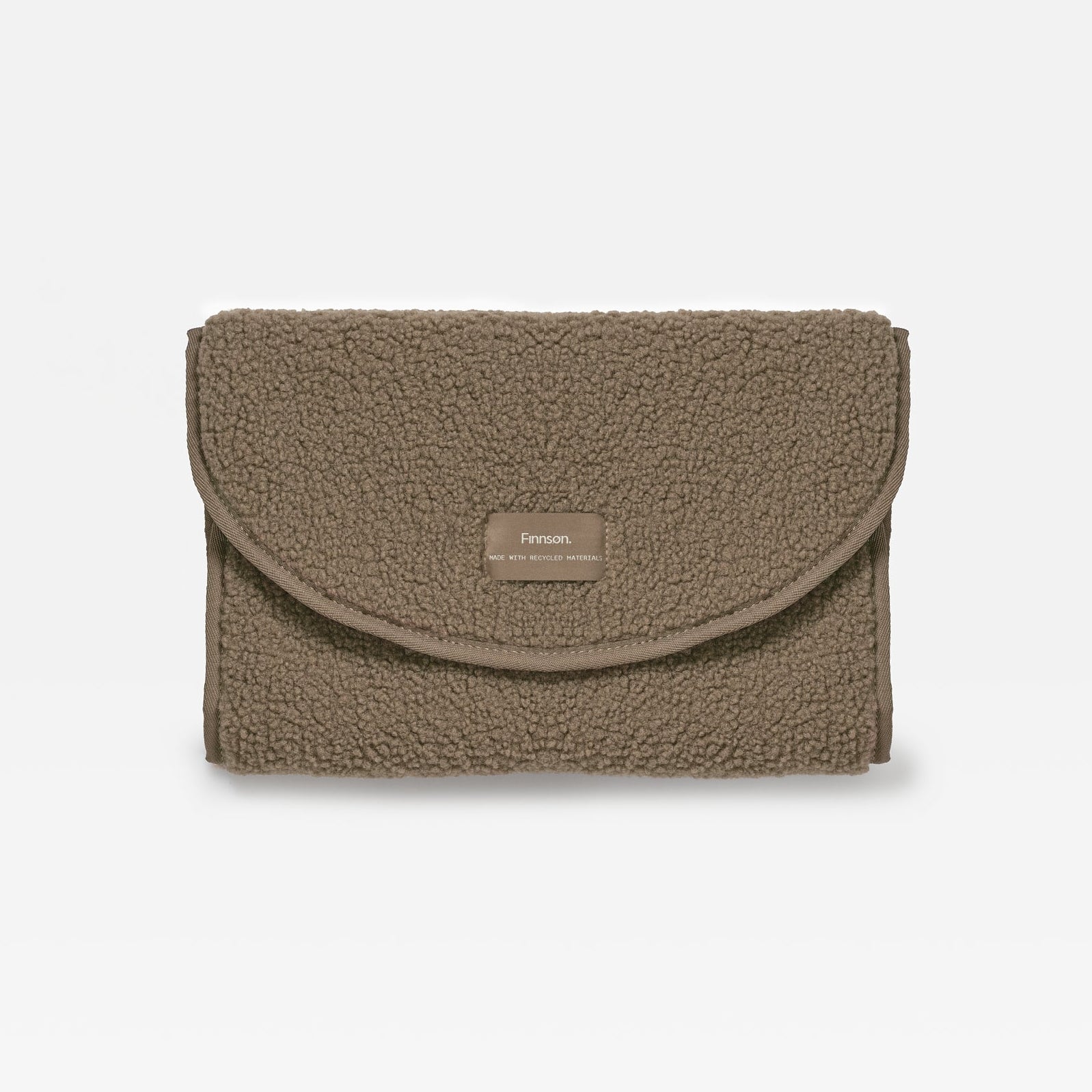 A mocha teddy changing mat with a small rectangular woven label on the front flap, set against a plain white background.