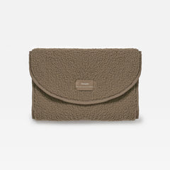 A mocha teddy changing mat with a small rectangular woven label on the front flap, set against a plain white background.