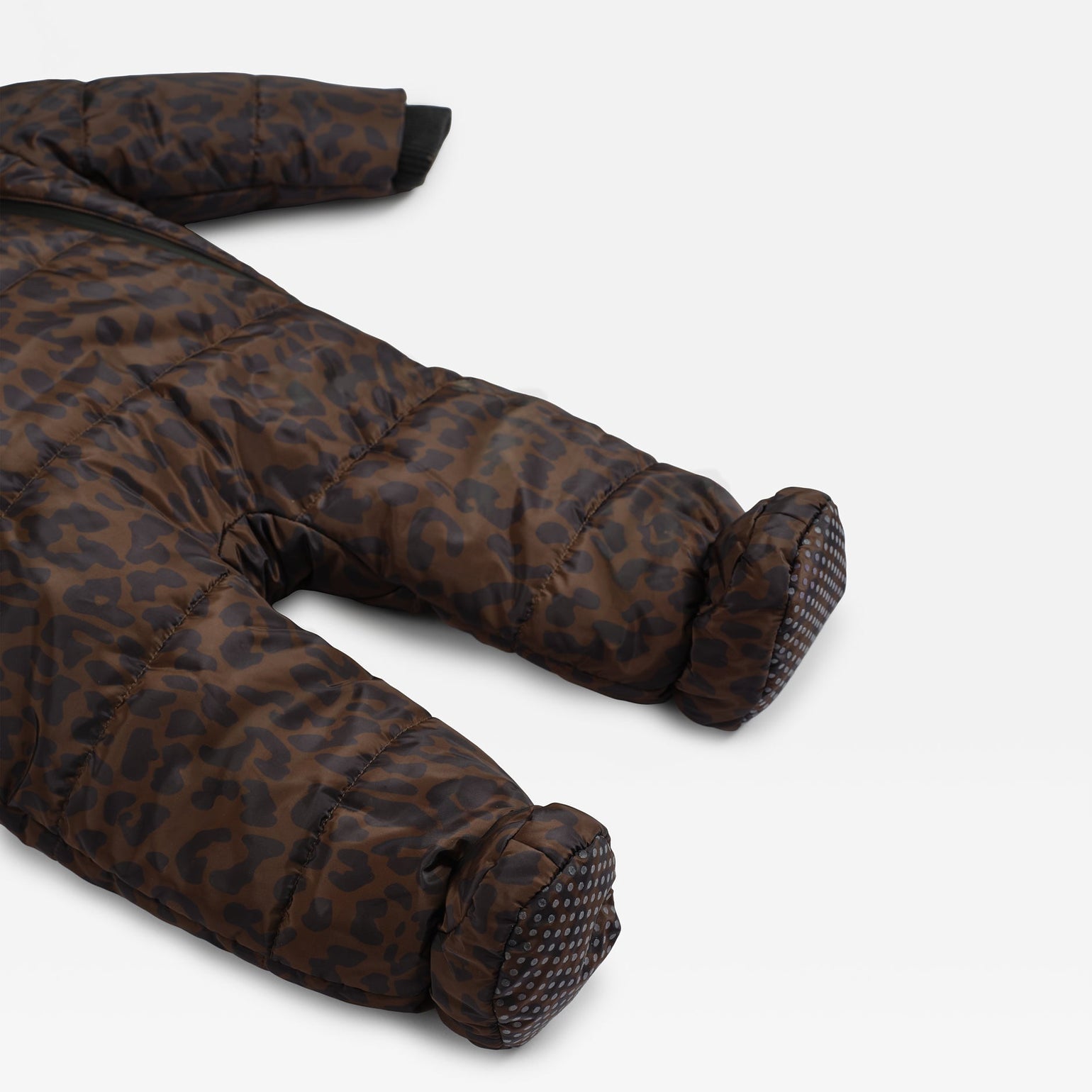 A close-up of the Anders brown and black leopard-print puffer footed one-piece snowsuit, showing the quilted fabric texture and pattern on the legs and feet, set against a plain light gray background.